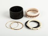three different rings and bracelets sitting on top of a white surface