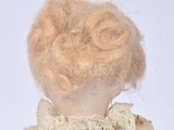 an old fashioned doll with a pink hair and a white dress