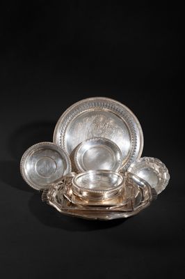 an antique silver plate with a bowl and saucer on a black background