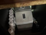 many rolls of toilet paper on a shelf next to a toaster
