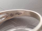 a close up of a silver ring with a diamond on it