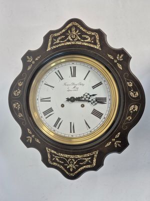 une horloge accrochée au mur à côté d'une horloge murale