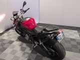 a red motorcycle that is parked on a checkered floor