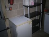 a small white refrigerator in the corner of a room