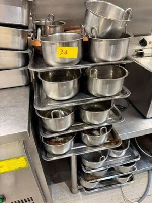 de nombreuses casseroles et poêles sur l'étagère de la cuisine