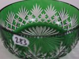 a green glass bowl with white flowers on it