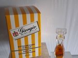 un petit flacon de parfum à côté d'un coffret de parfum