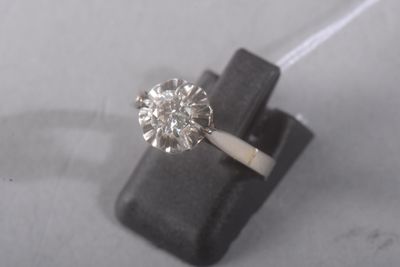 une photo d'une bague en diamant posée sur un morceau de bois