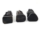 three pairs of black leather shoes with black soles on a white surface