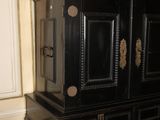 a black cabinet with a vase on top of it