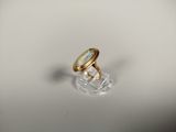une photo d'une bague en or posée sur une assiette transparente