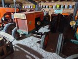 many old tractors in the garage of this building