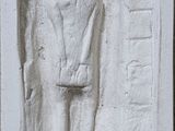 un relief blanc représentant un homme tenant un couteau à la main