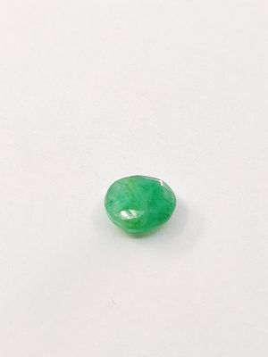 a close up of a green jade stone on a white surface