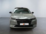 the front of a silver car in a showroom with a white wall