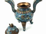 a blue and gold teapot with a lid next to it
