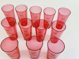 a lot of red glasses sitting on a white surface