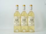 trois bouteilles de vin blanc posées les unes à côté des autres sur une table