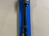 a close up of a pen with a black handle on top of a blue package