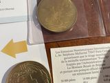 a gold coin sitting on top of a table next to a piece of paper