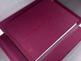 purple and silver folders are stacked on top of each other on a white surface