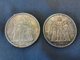 two silver coins, one of which has a picture of a man and a woman on it
