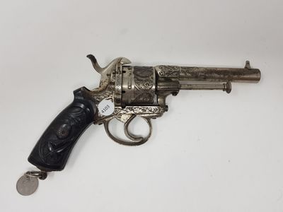 un vieux revolver argenté avec une crosse noire sur un fond blanc