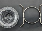 a glass of water and a metal object on a table