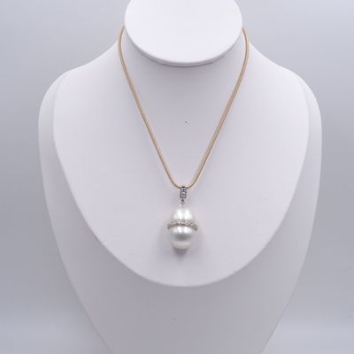 un pendentif composé d'une perle blanche et de diamants, monté sur une chaîne en or