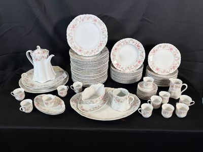 many plates and cups on a table with a black background