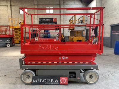a red scissor sitting in the middle of a warehouse
