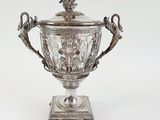 an antique silver plated cup with two birds on it