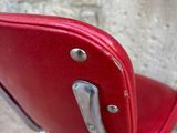 a red chair sitting in front of a brick wall
