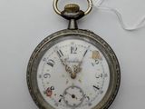 une vieille montre de poche à laquelle est accrochée une chaîne sur le côté