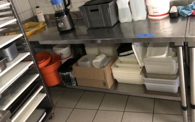 une cuisine équipée d'une table en inox et de nombreux récipients