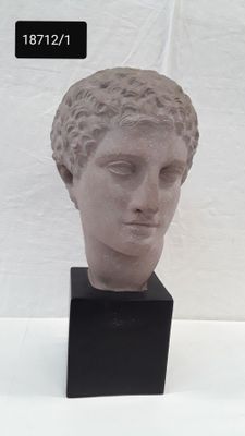statue of a woman ' s head with her eyes closed on a black stand