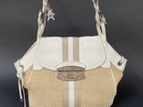 a close up of a white and beige purse on a black background