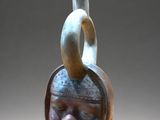 un vase marron sur lequel est représenté un visage