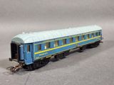 a blue and yellow train car sitting on a gray surface