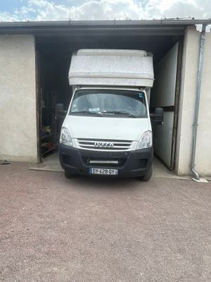 une camionnette blanche garée devant un garage