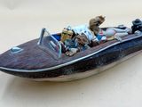 une figurine représentant un homme et un chien à bord d'un bateau
