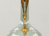 a vase that is sitting on a table with a candle on it