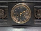 a black clock with roman numerals on top of it