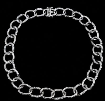 un gros plan d'un bracelet à chaîne en argent sur fond noir