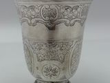 une tasse en argent antique avec un motif floral sur le bord