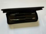 a black case with three pens in it on a table
