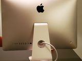a white apple computer on a desk with a cable plugged into it