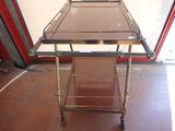 a metal cart with a glass top on the floor