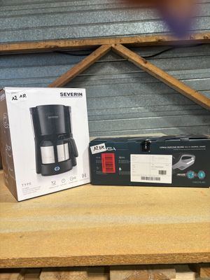 two boxes of coffee machines sitting on top of a wooden table