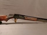 un fusil avec un canon et une crosse en bois sur fond blanc